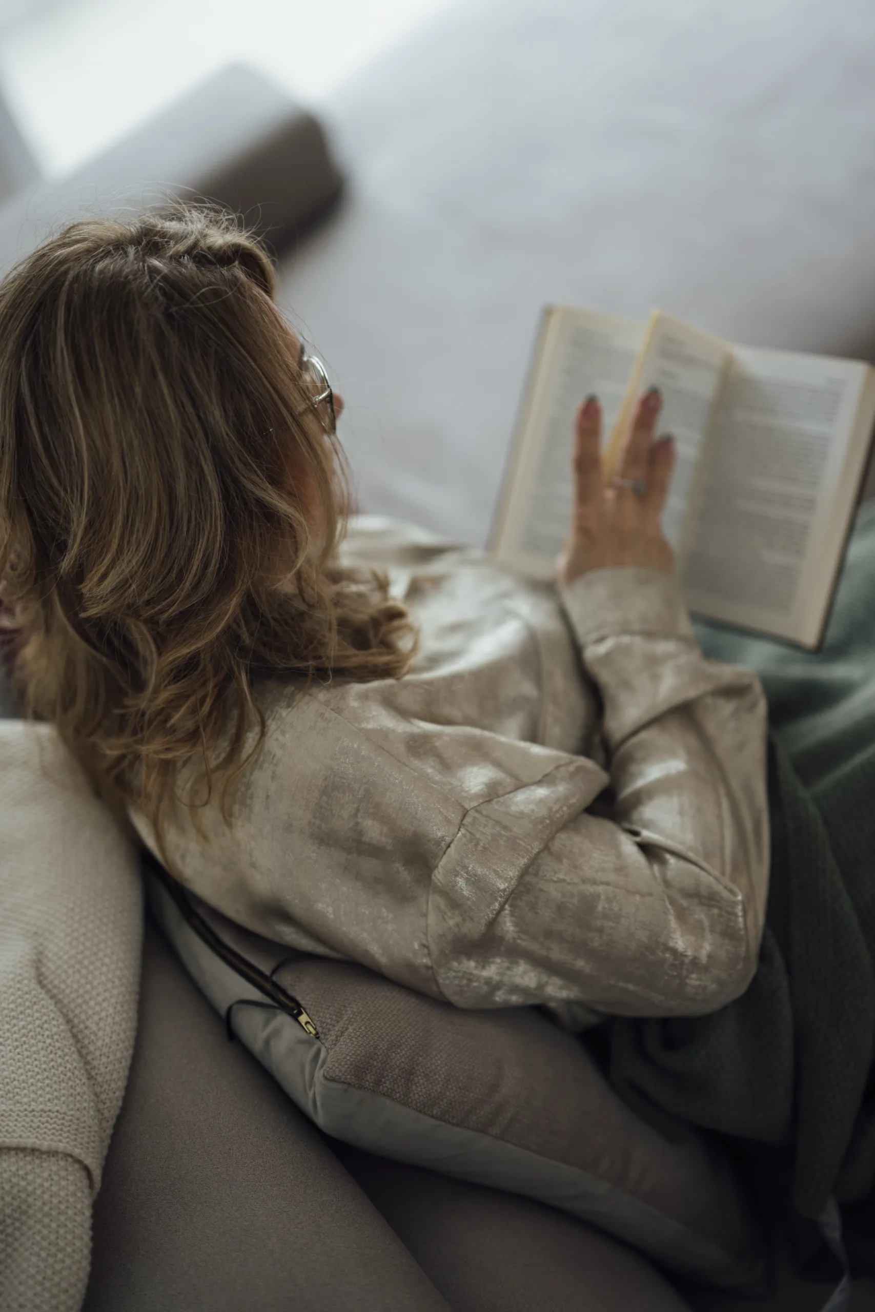 Frau liest ein Buch auf dem Sofa
