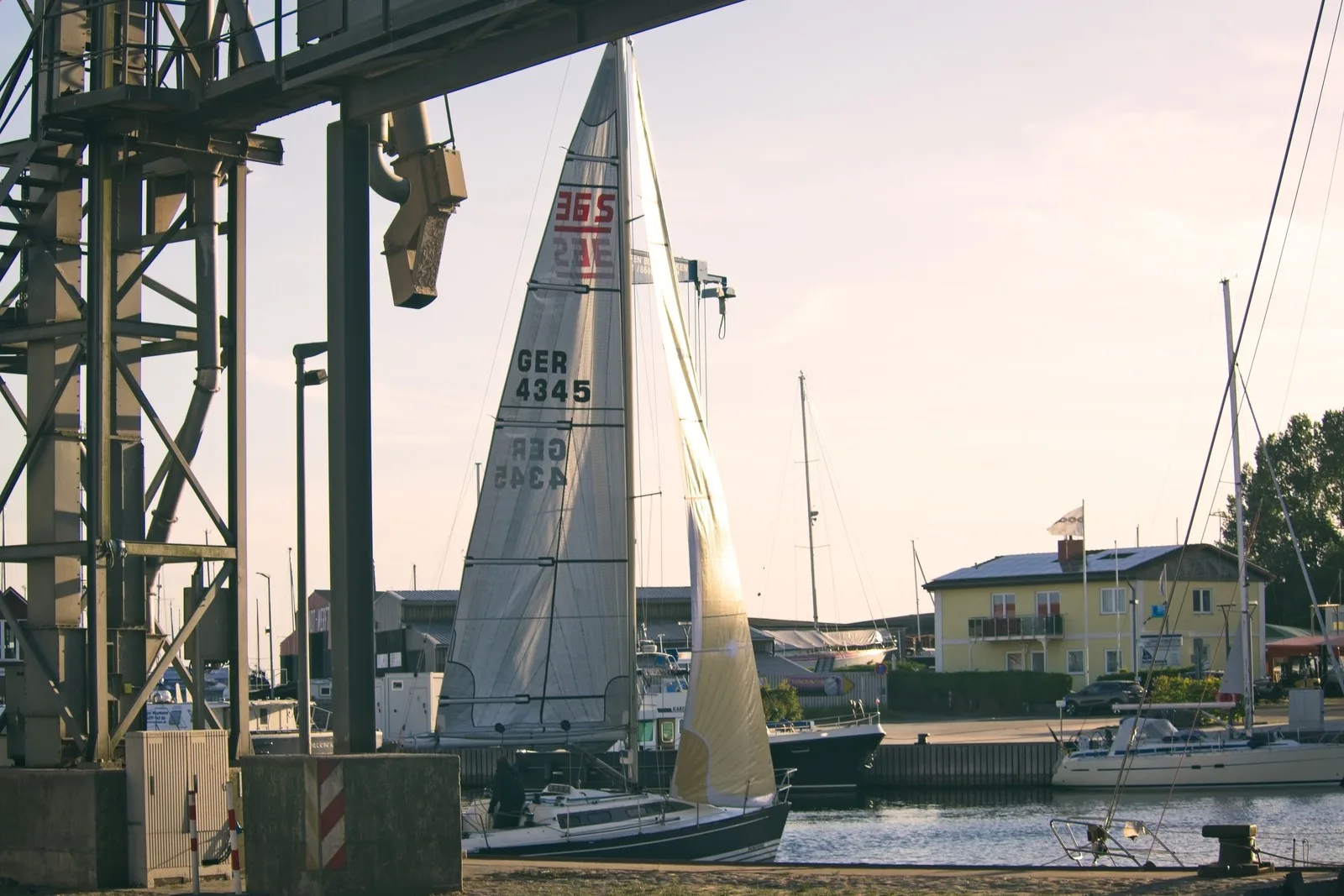 Segelboot mit gesetzten Segeln im Hafen von Burgstaaken auf Fehmarn