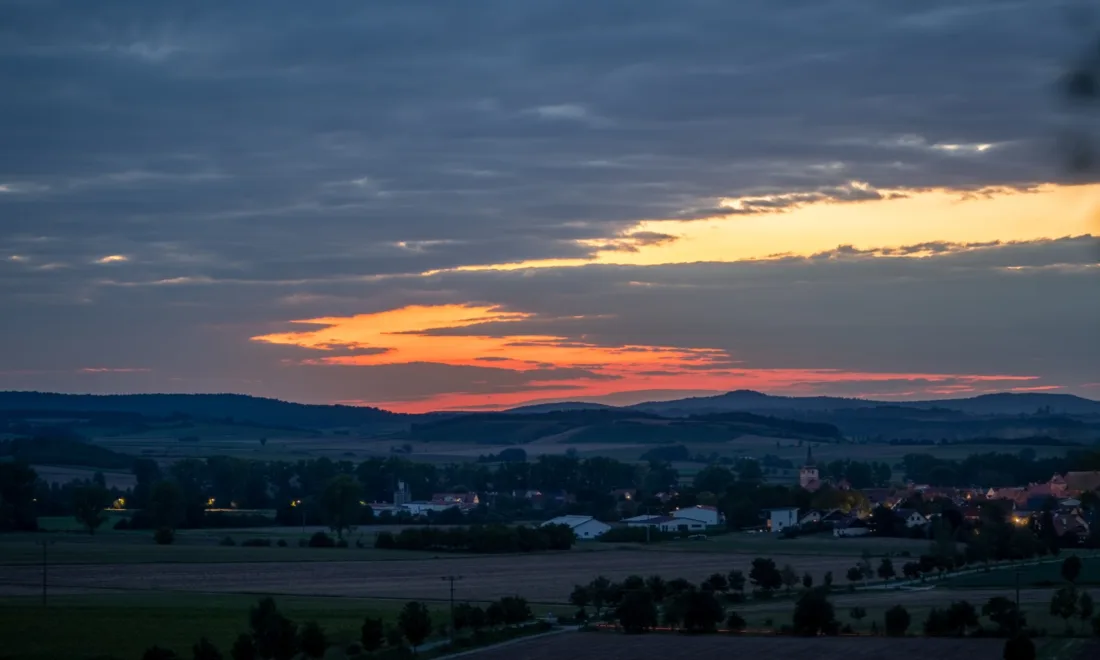 Sonnenuntergang über dem Dorf Ipsheim mit Kirchturm