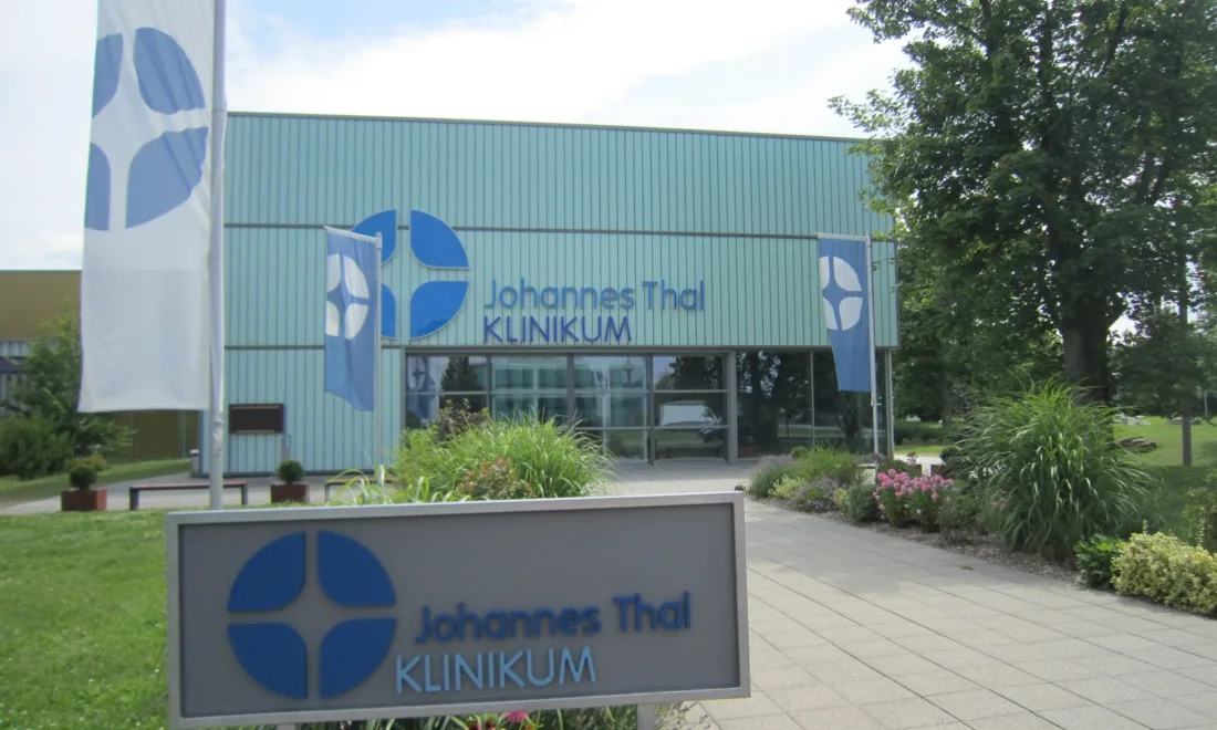 Das Johannes-Thal-Klinikum in Erfurt mit Schriftzug am Gebäude und auf dem Hinweisschild