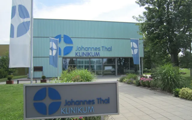 Das Johannes-Thal-Klinikum in Erfurt mit Schriftzug am Gebäude und auf dem Hinweisschild