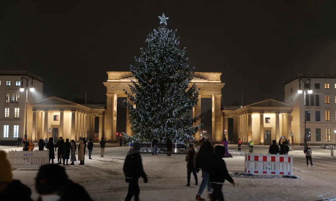 Weihnachtsbaum mit Schnee am Pariser Platz in Berlin bei Nacht