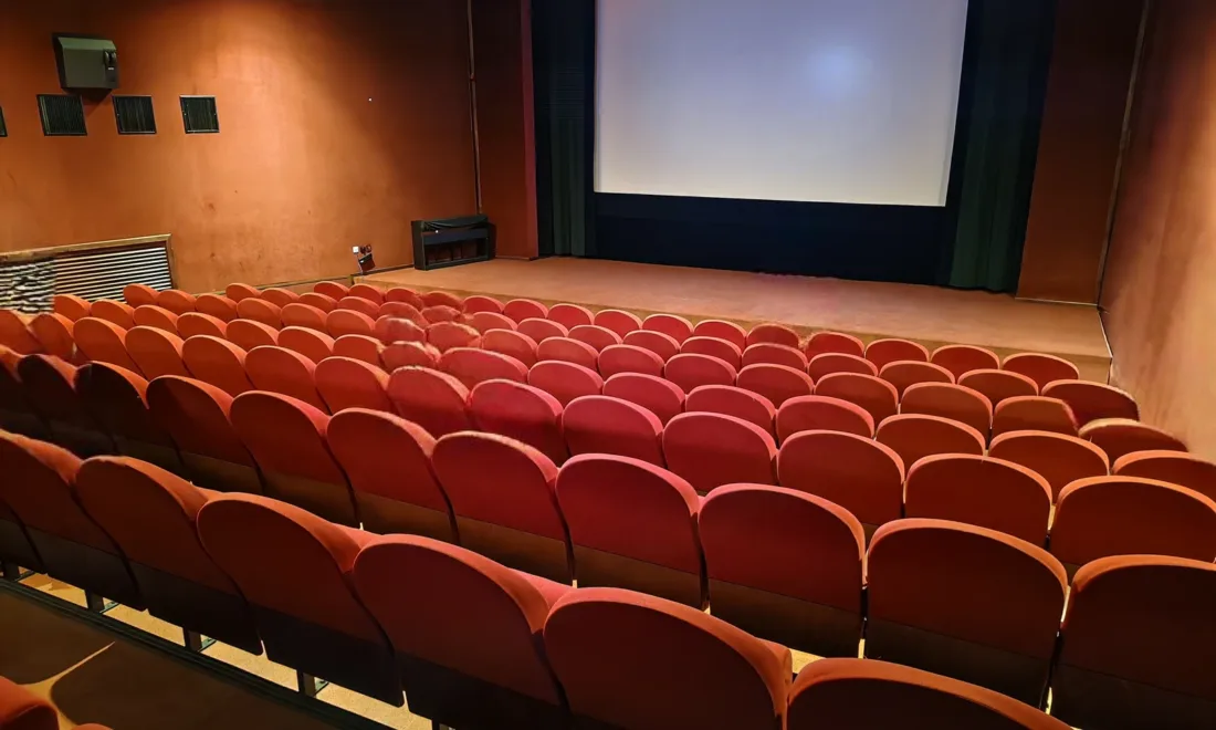 Kinosaal des Kino Atlas in Prag mit roten Sitzreihen und großer Leinwand