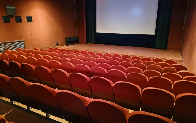 Kinosaal des Kino Atlas in Prag mit roten Sitzreihen und großer Leinwand
