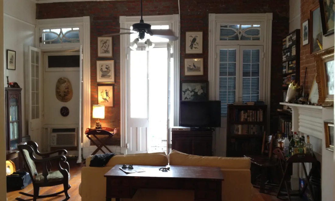 Ein helles Wohnzimmer mit Flachbildfernseher auf einem Schrank und Sofa